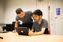 Tutor helps student with a problem on their computer as they prepare to apply to Oxford or Cambridge